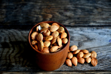 Almond nuts in a wooden bowl on the background of old boards.