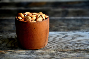 Almond nuts in a wooden bowl on the background of old boards.