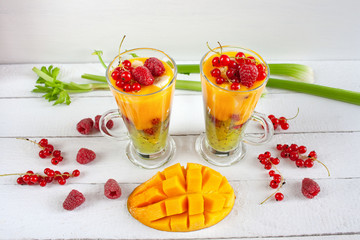 Kolorowe wielowarstwowe smoothie z mango, kiwi, selerem naciowym, porzeczkami i malinami