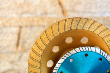 Part of the diamond grinding wheels on background an orange-golden sandstone wall.