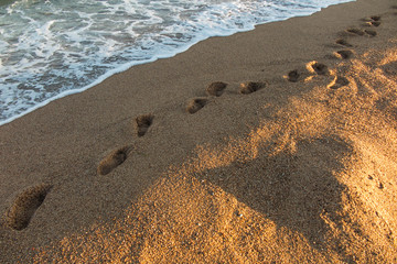 footprints flooded with sea water on the beach sand in the Calella area of Spain