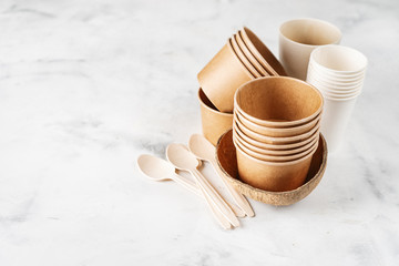 Eco craft paper tableware. Paper and bamboo cups and wooden cutlery on white background