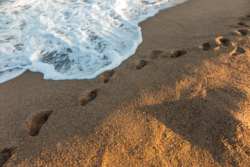 footprints flooded with sea water on the beach sand in the Calella area of Spain