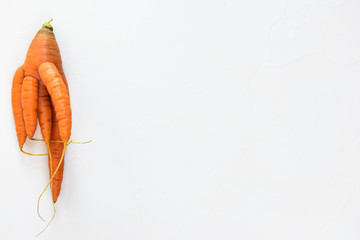 Ugly carrot on a white background. Ugly food concept, top view, copy space.