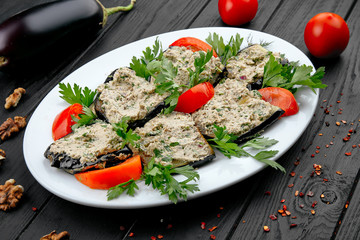 Eggplant Rolls with tomato. Traditional georgian snack. Vegan food on dark wooden background. Healthy, dieting food concpet with copy space.