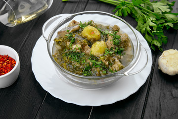 Georgian rich soup with lamb and spices on dark background with copy space. Georgian cuisine. Food for lunch. Tasty soup bowl. Restaurant concept