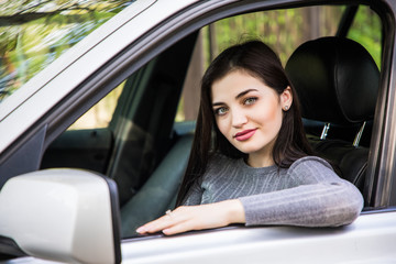 Obraz na płótnie Canvas Smiling woman sitting in car looking from window