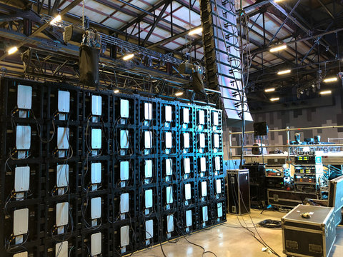 Installation of professional sound, light, video and stage equipment for a concert. Backstage area with amplifiers, flight cases and radio microphones.