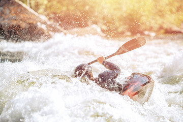 Whitewater kayaking, extreme sport rafting. Guy in kayak sails mountain river