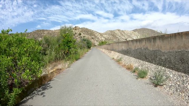 paved road parallel to Nacimiento river next to Santa Cruz de Marchena, province of Almeria, Andalusia, Spain