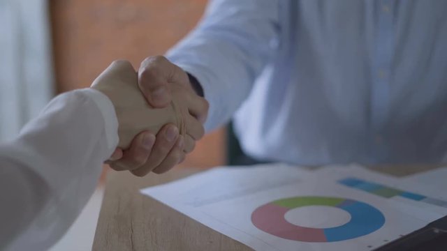 women's hands are typing on the keyboard, running the graph for comparison, and then shaking hands with a partner 4K