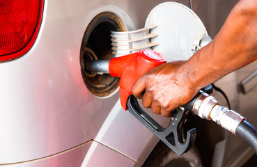 Detail hand of worker man refuelling car at the petrol station. Concept photo for use of fossil fuels (gasoline, diesel) in combustion engines, air pollution and environment and occupational health. - 280480579