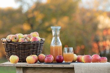 Fresh apple juice from apples in the fall after harvest, served on a table