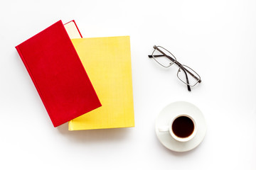 Books with empty cover near glasses, coffee on white desk background top view