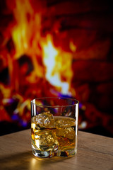 Glass of whiskey in front of a fireplace