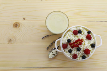 Composition with cottage cheese, fresh berries and yogurt on wooden table