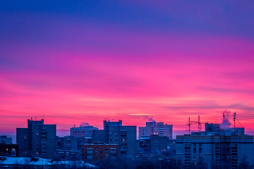 Fototapeta premium The sunset scarlet clouds. City building