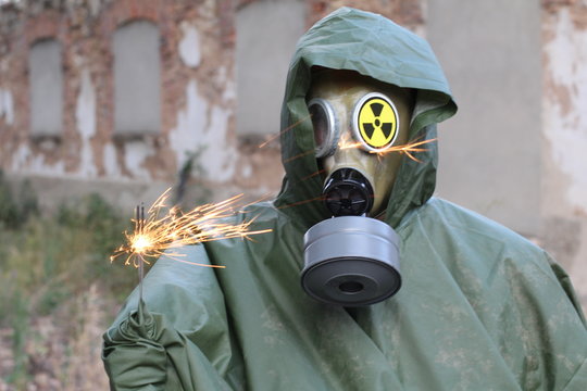 Man with gas mask holding a sparkler 
