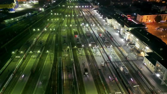 flying over the paths of the night the train station , Yekaterinburg, Russia . People and trains in the night illumination paths. 4k