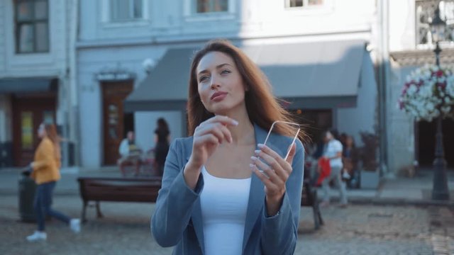 Close up woman uses a futuristic glass tablet with the latest advanced holographic technology on street outdoors internet mobile display telephone city portrait modern innovation slow motion. The best