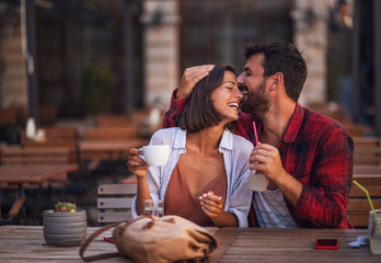 A love couple sitting in a cafe laughing cheerfully