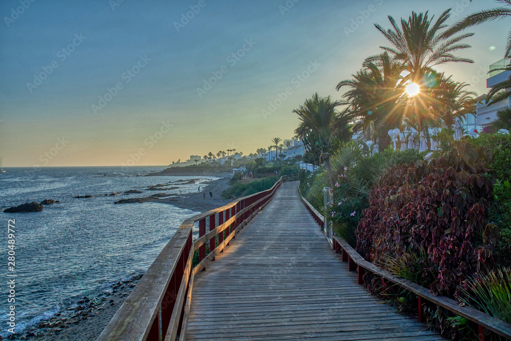 Wall mural puente sobre arena en playa con vistas al mar