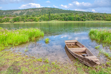 Naklejka premium Old wooden fishing boat on the river shore