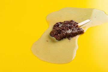 side view studio shoot of red bean popsicle in a melting process on yellow background 2