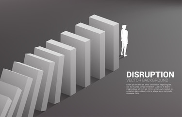 Silhouette of businessman standing at the end of domino collapse. Concept of business industry disrupt