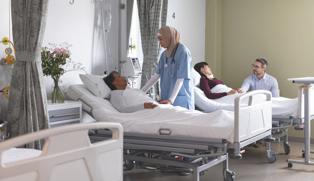 Doctors interacting with patients in the ward