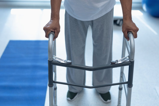 Male patient walking with walker in the ward at hospital