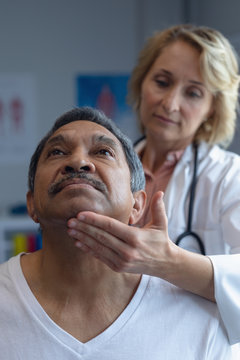 Doctor examining patient's neck in hospital