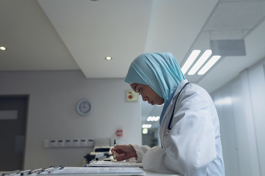 Female doctor reading documents at reception