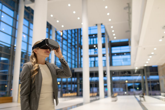 Businesswoman using virtual reality headset in the lobby at modern office