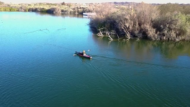 Aerial shot of a kayaker paddling across  a beautiful blue lake in Yuma, Arizona
