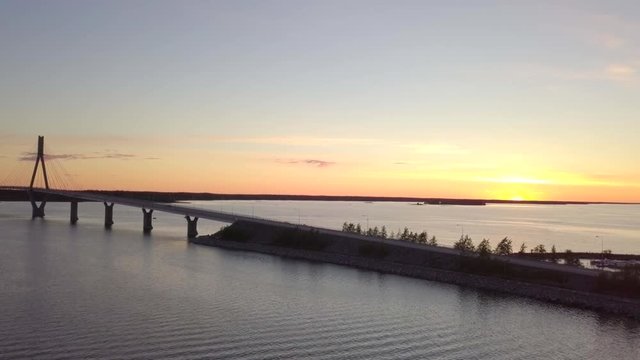 Aerial, static, drone shot, of a truck, driving over the Raippaluodon silta bridge, at sunset, in the Kvarken archipelago, on a sunny, summer evening, in,Vaasa, Ostrobothnia, Finland