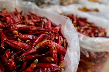 Close up a heap of dry red peppers ( dried chili ) in plastic bag in grocery market. Blur background