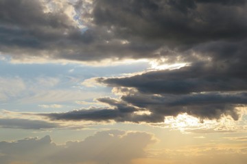 Obraz premium Golden sunset with black dramatic clouds in the sky, natural cloudscape