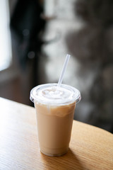 Iced Chai Latte in To Go Cup on Table, Coffee on Wooden Bar in Cafe, Close up photo