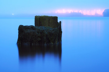 Calm on the river. Industrial piles