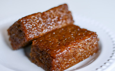 Wajik or wajid on white background.  Wajik is traditional snack made with steamed glutinous (sticky) rice and further cooked in palm sugar, coconut milk, and pandan leaves.