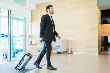 Male Entrepreneur Arriving At Hotel With Luggage