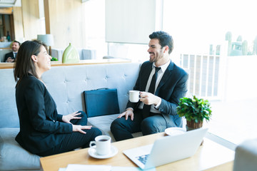 Fototapeta premium Attractive Colleagues Talking During Coffee Break In Lobby