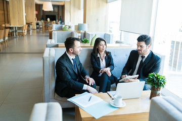 Latin Male And Female Managers Planning In Lobby