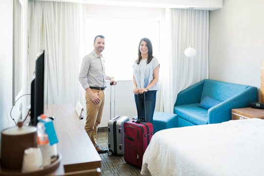 Honeymooners With Luggage In Hotel Room