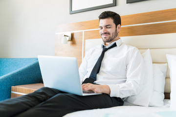 Male Entrepreneur Using Laptop In Hotel Room