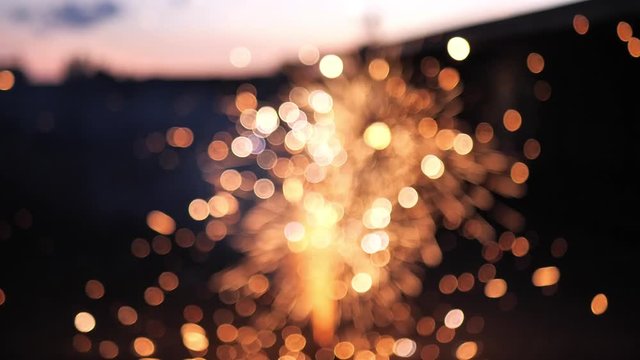Slow motion shot of fireworks going off on the ground, as the flames are intentionally out of focus creating beautiful bokeh bubbles and blurring.