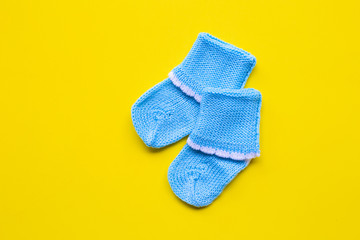 Baby socks on yellow background.