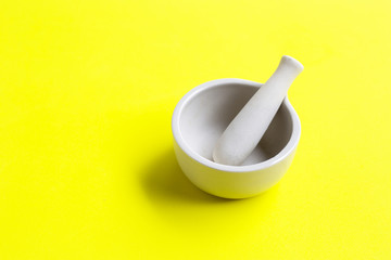 Mortar and pestle on green yellow background.