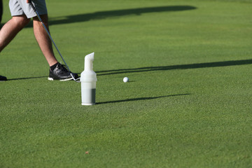 a bottle of sand is used to replace divots on a golf course